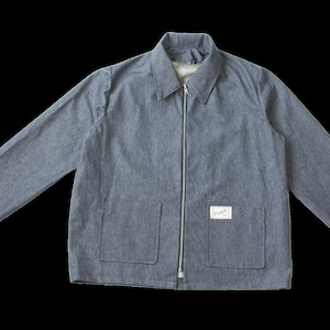 Może przedstawiać: Niebieska kurtka dżinsowa z pełnym zamkiem błyskawicznym, dwiema przednimi kieszeniami i małą etykietą po prawej stronie. Kurtka ma długie rękawy i kołnierz. Kurtka jest w kolorze jasnoniebieskim.