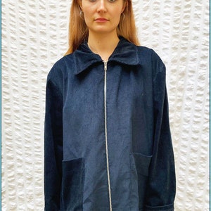 May include: A dark blue corduroy jacket with a zipper closure and a large pocket on the front. The jacket has a collar and long sleeves. The text "Ollie Jacket" is visible in the bottom right corner of the image. The text "PINCH Step by step sewing patterns" is visible in the top left and right corners of the image.