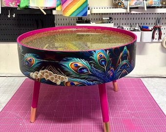 Ronde salontafel, pauwenmotief, blauwe, groenblauwe en turquoise veren. Helderroze. Ronde tafel, verwijderbaar blad voor opberging. Bijzettafel lounge