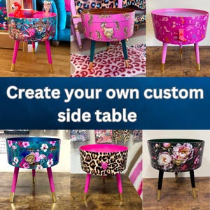 May include: A collection of custom side tables with various designs. Each table has a round top and three legs. The legs are painted in bright colors, with gold-colored tips. The table tops feature animal prints, floral patterns, and tropical scenes.