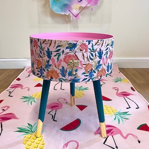 Pink and green floral wooden round side table with leaf and flower design. Inbuilt drawer and three legs with gold painted palm tree handle