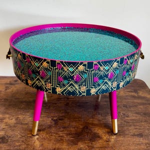 Runt soffbord, knallrosa och blågrön art déco-leopard. Turkos glitter. Gepard runt bord, lyft av toppen för förvaring. Sidobord för lounge