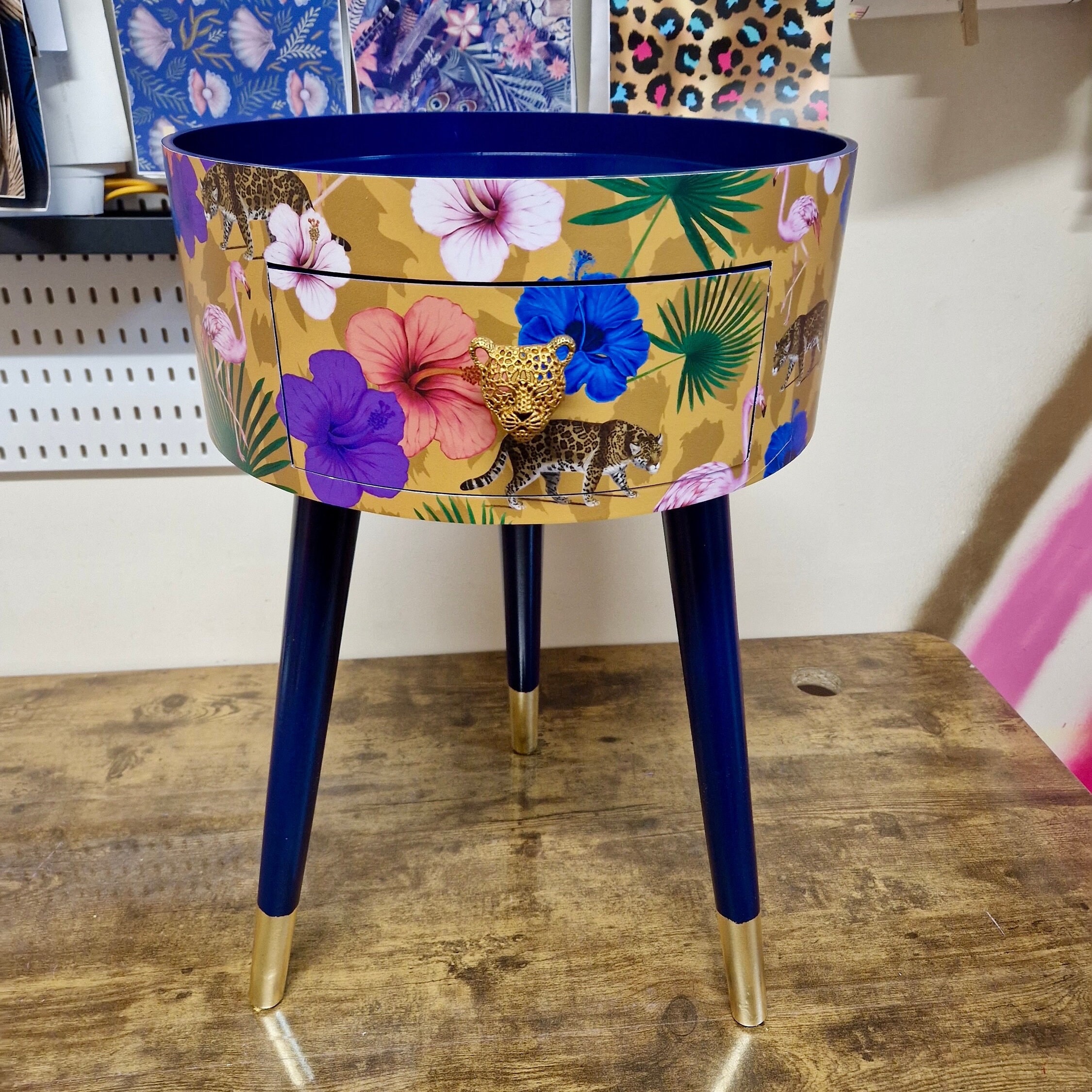 Comodino rotondo giallo e blu scuro. Comodino dal design tropicale con fenicotteri e leopardi. Tavolino con ghepardo e fiori