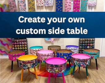 May include: Create your own custom side table.  A variety of colorful side tables with different patterns and designs are displayed on a white surface.  The tables are all about 18 inches tall and have a drawer.