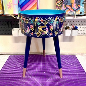 Art deco bed side table, navy blue, gold and pink bird design. Bedroom nightstand, colourful bedside end table. Taller legs with drawer