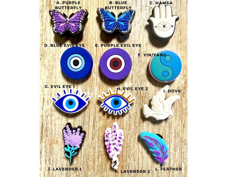 Pode incluir: Um conjunto de 12 pingentes coloridos com v&aacute;rios designs, incluindo borboletas, olhos maus, uma pomba, uma m&atilde;o de hamsa, um s&iacute;mbolo yin yang e flores de lavanda. Os pingentes s&atilde;o feitos de um material macio e emborrachado e s&atilde;o perfeitos para adicionar um toque de personalidade aos seus sapatos, bolsas ou outros acess&oacute;rios.