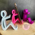 Humorous smartphone holder – sitting figure as a cell phone stand, funny gift/office & desk decoration available in many colors product logo