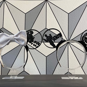 May include: Two black mouse ears with white bow tie and black silhouette designs on each ear. The designs include a Star Wars symbol, a silhouette of a couple with the text "I Love You", a silhouette of a couple with the text "I Know", and a silhouette of the Millennium Falcon.