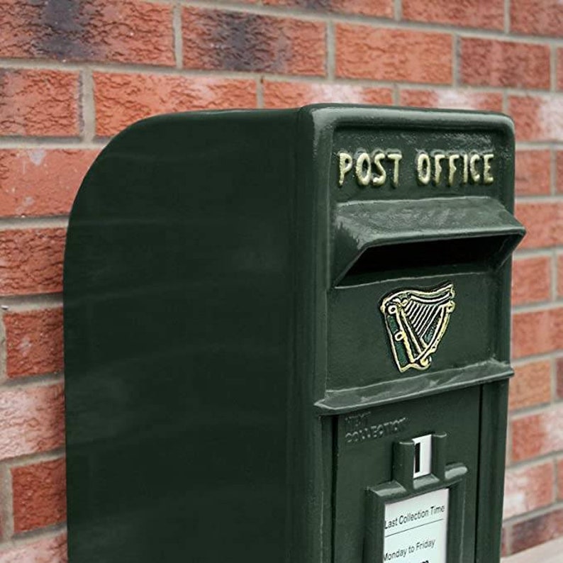May include: A dark green metal mailbox with the words "POST OFFICE" in gold lettering. The mailbox has a slot for mail and a harp design on the front.