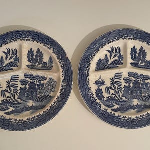May include: Two blue and white divided plates with a willow pattern design. The plates are divided into three sections.