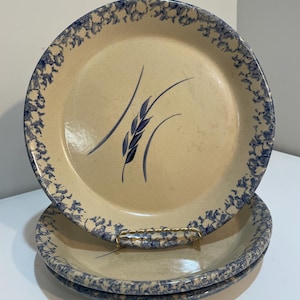 Puede incluir: Juego de tres platos de cerámica con un esmalte moteado azul y blanco. Los platos presentan un diseño de trigo azul.