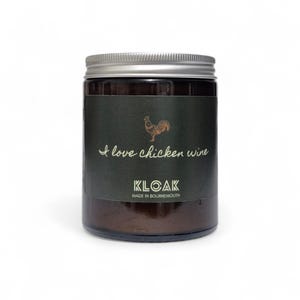 May include: A glass jar with a silver lid and a dark green label. The label features a gold rooster illustration and the text "I love chicken wine" and "KLOAK MADE IN BOURNEMOUTH".