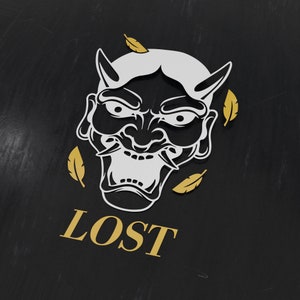 Könnte beinhalten: Stilisierte Illustration einer weiß-schwarzen Dämonenmaske mit Hörnern und scharfen Zähnen, begleitet von goldfarbenen Federakzenten. Das Wort "LOST" ist goldfarben auf schwarzem Hintergrund gedruckt.