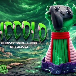 May include: A green Piccolo controller stand holding a black game controller. The stand has a red band, pink and green sections, and a purple base. The words "Piccolo Controller Stand" are displayed in green.