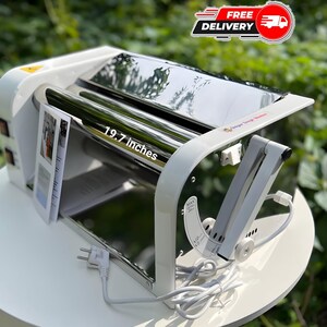 May include: A white electric dough sheeter with a polished metal roller measuring 19.7 inches in width. The machine features a side control panel with two switches, a white power cord with a plug, and an adjustable metal arm on the right side.