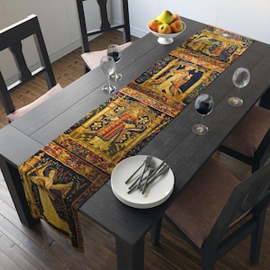 May include: A long rectangular table runner featuring a repeating medieval-style tapestry print with gold, red, and dark blue colors. The design depicts figures in historical attire within arched architectural frames, laid across a dark wooden table.
