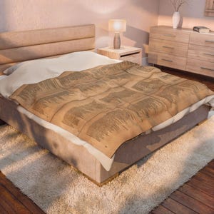 May include: A rectangular throw blanket featuring a vintage-style sepia-toned print of aged parchment paper with columns of black printed text. The blanket is draped over a bed with a white sheet, a beige upholstered headboard, and a wooden frame.