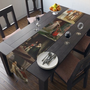 May include: A brown wooden table with a white table runner featuring a collage of medieval paintings. The table runner has a scene of a knight kneeling before a woman, a knight and a woman standing in a castle, and a knight and a woman standing in a forest. The table is set with two place settings, each with a white plate, a fork, and a wine glass.