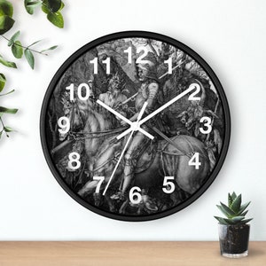 May include: Black and white clock with a vintage engraving of a knight on horseback. The clock face has white numbers and hands.