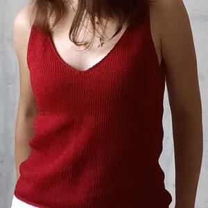 May include: A red ribbed tank top with a v-neckline.