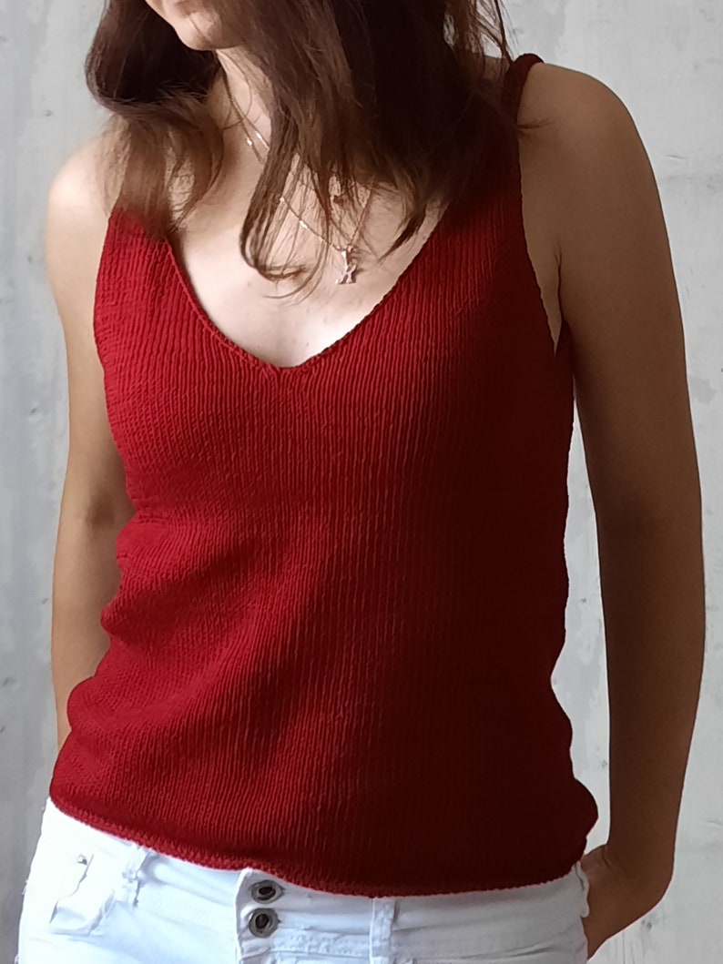 May include: A red ribbed tank top with a v-neckline.