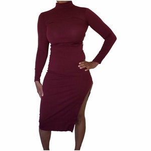 May include: A burgundy long-sleeved midi dress with a high neck and a side slit.