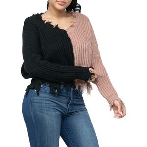 Könnte beinhalten: Ein schwarz-rosa Farbblockpullover mit ausgefransten Säumen und langen Ärmeln.