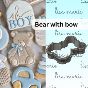 May include: A cookie cutter in the shape of a bear with a bow. The cutter is made of metal and is silver in color. The cutter is on a white background.