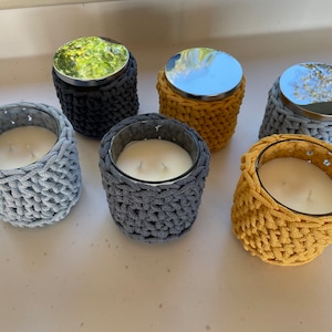 Crocheted cotton candle holder containing scented candle