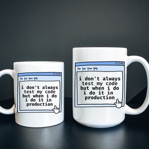 May include: Two white coffee mugs with a blue and black design. The mugs feature a computer window with the text "i don't always test my code but when i do i do it in production".