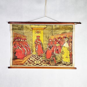 May include: A framed print depicting a historical scene with figures in red robes and hats, gathered in a room with a checkered floor. The print is mounted on wooden rods and suspended by a string.