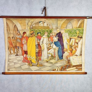 May include: A vintage educational chart depicting a scene from medieval times. The chart features a group of people in period clothing, including a king, a bishop, and other figures. The scene is set in a church or cathedral, with bookshelves and other details. The chart is printed on paper and has a wooden frame.
