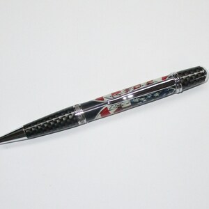 May include: A black and silver pen with a carbon fiber barrel and a red, white, and blue design. The pen has a silver clip and a silver cap.