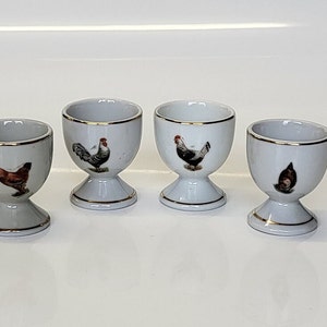 A collectible set of four Foreign stamped porcelain egg cups with different hen illustrations