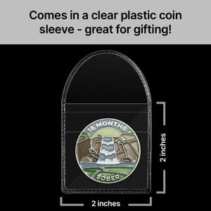 May include: A clear plastic coin sleeve with a silver coin inside. The coin has a green, brown, and white design with the text "18 MONTHS SOBER". The sleeve is 2 inches wide and 2 inches tall.