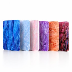 Könnte beinhalten: Ein Set aus sechs rechteckigen Acrylplatten, die in einer Reihe angeordnet sind und jeweils ein einzigartiges Marmormuster aufweisen. Die Farben umfassen tiefes Blau, Hellblau, zartes Rosa, leuchtendes Lila, helles Orange und dunkles Magenta.