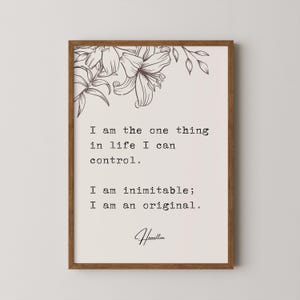 May include: A framed print with a floral design at the top and a quote by Alexander Hamilton that reads: "I am the one thing in life I can control. I am inimitable; I am an original."