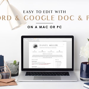 May include: A laptop computer displaying a resume template for a construction project manager. The resume is titled "Daniel Miller" and includes sections for "Profile Summary", "Education", and "Skills". The laptop is on a white desk with a lamp, a glass of water, a candle, and a bouquet of white roses.