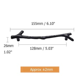 May include: A black, branch-shaped cabinet pull with a length of 6.10 inches (155mm) and a height of 1.02 inches (26mm). The pull's handle is 5.03 inches (128mm) long. The image includes measurements and the text "Approx &plusmn;2mm."