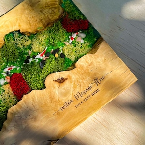 May include: A wooden decorative piece with a live edge design. The piece features a vibrant green moss landscape with miniature koi fish and red accents. The text "custom message here" is engraved on the wood.