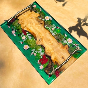 May include: A rectangular serving tray with a vibrant green resin base. The tray features a natural wood centerpiece, decorative koi fish, and floral accents. The tray has metal branch-shaped handles.