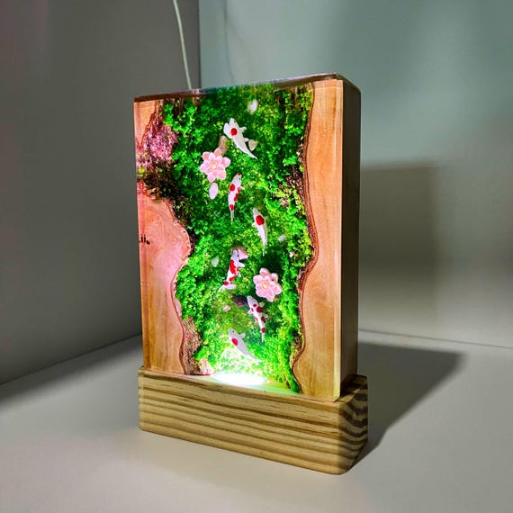 A tiny self-contained koi pond frozen in glowing green resin — 126 favorites don't lie, this is the kind of desk lamp people stop and ask about.
