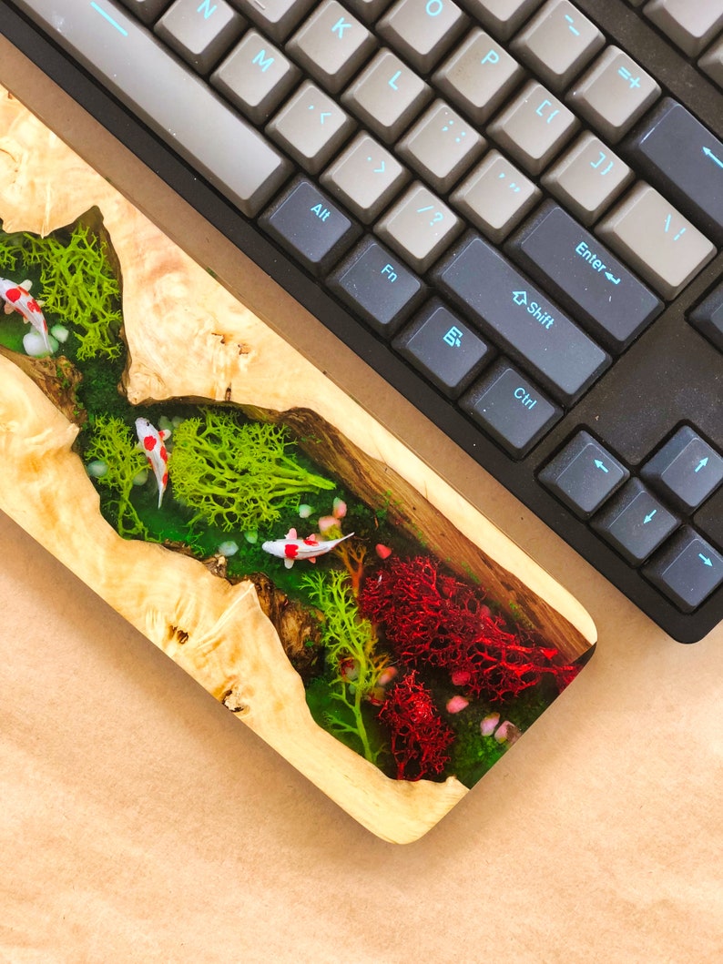 May include: A wooden resin art piece with a riverbed design featuring green moss, red coral, and white koi fish.