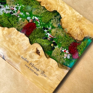 May include: A rectangular wooden art piece with a miniature landscape featuring green moss, small rocks, and red accents. Three koi fish swim in the miniature pond. The wooden frame has a light brown color and the text "custom Message Here" is visible.