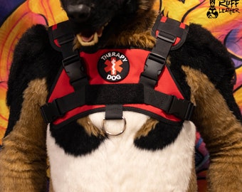 May include: Red and black therapy dog harness with a black D-ring and a red patch that says "Therapy Dog" with a medical symbol.