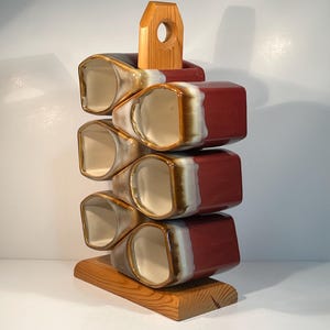 May include: A trio of ceramic mugs with a speckled, matte finish in cream, grey, and black. Each mug features a simple, modern design and a rounded handle. Suitable for tea or coffee, these mugs offer a minimalist aesthetic.