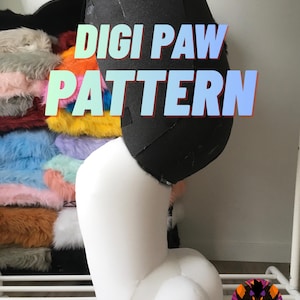 May include: A digi paw pattern in progress, with a black upper section and a white lower leg and foot. The text "DIGI PAW PATTERN" is displayed in a colorful gradient. A selection of colorful faux fur is visible in the background.