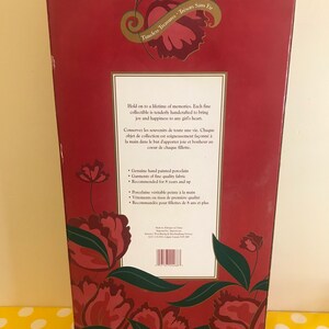 May include: Red box with a floral design and the text "Timeless Treasures Tr&eacute;sors Sans Fir". The box contains a porcelain doll collectible. The text on the box reads "Hold on to a lifetime of memories. Each fine collectible is tenderly handcrafted to bring joy and happiness to any girl's heart."