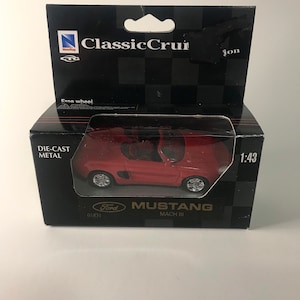 May include: A red die-cast metal Ford Mustang Mach III model car in a black box. The box has the text "Classic Cruisin'" and "Die-Cast Metal". The model is 1:43 scale.