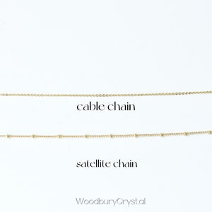 May include: Two gold chains on a white background. The top chain is a cable chain and the bottom chain is a satellite chain. The text "WoodburyCrystal" is at the bottom of the image.
